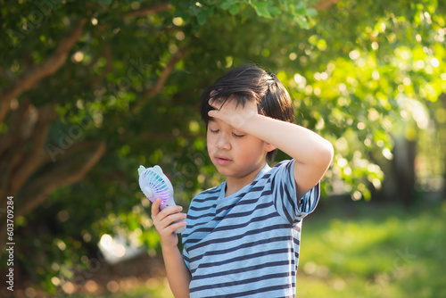 Asian child using a handy fan