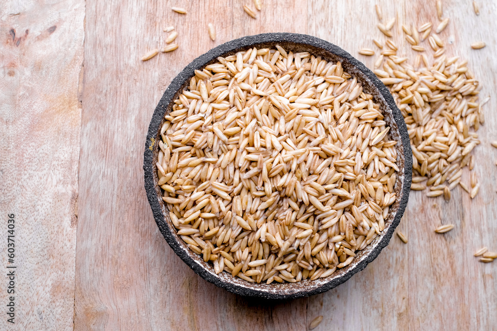 oat seeds in a black plate isolated on white background top view oat seeds in a black plate isolated on white background top view