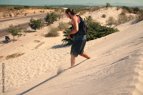 A carefree male Caucasian tourist running down the desert sand dunes in Mui ne, Vietnam