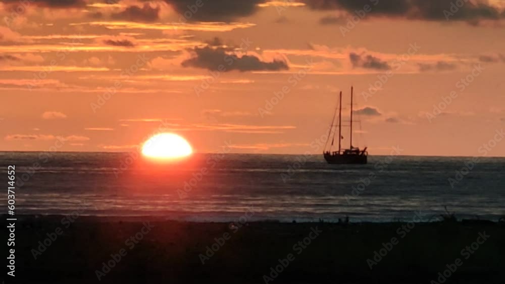 Costa Rica, Quepos, evening, sunset, pink sky, sea, birds fly from right to left, silhouette of a ship in the sea. The sun gradually sets below the horizon until it disappears completely Costa Rica, Quepos, evening, sunset, pink sky, sea, birds fly from right to left, silhouette of a ship in the sea. The sun gradually sets below the horizon until it disappears completely