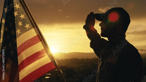 Silhouette of Military Salute of soldier for memorial day against flag at sunset