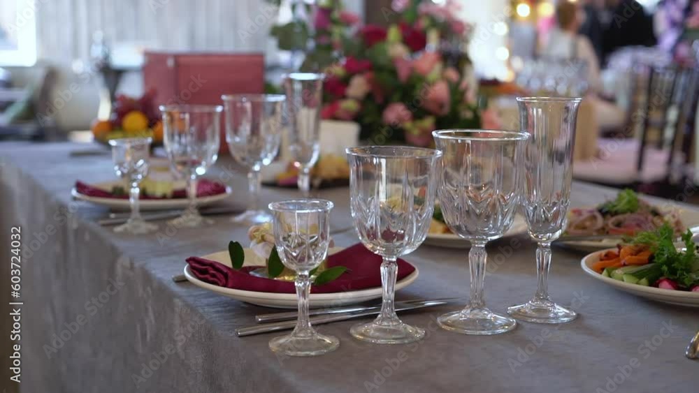 Served tables for a holiday in a restaurant. Glasses, plates, cutlery, napkins. Wedding decor, celebration dinner or party, reception indoors. No food. Served tables for a holiday in a restaurant. Glasses, plates, cutlery, napkins. Wedding decor, celebration dinner or party, reception indoors. No food.