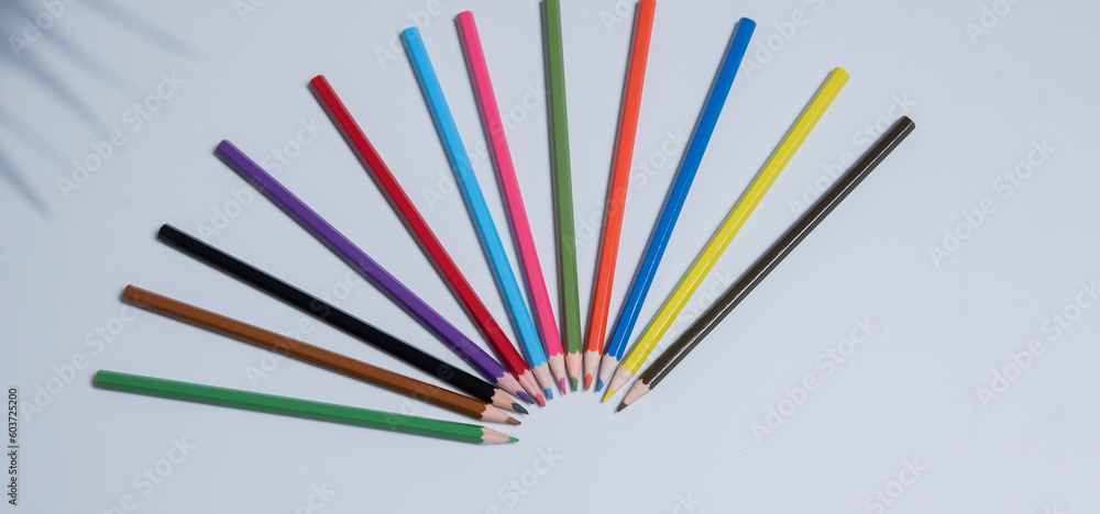 Colored pencils for drawing and coloring, on a white background. Figures made of colored pencils, school supplies