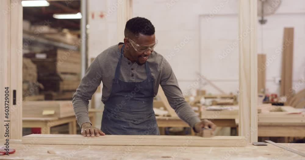 Carpentry, design and a black man sanding a plank in his factory for professional woodwork. Safety goggles, manual labor and expertise with a happy male carpenter working in his creative workshop Carpentry, design and a black man sanding a plank in his factory for professional woodwork. Safety goggles, manual labor and expertise with a happy male carpenter working in his creative workshop