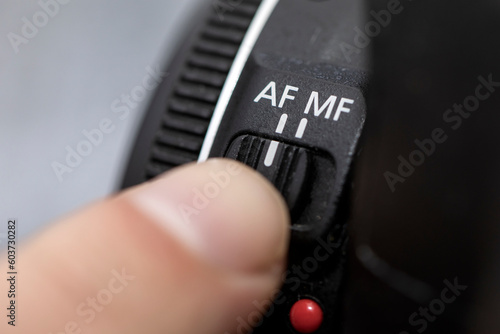 Tablou pe pânză Fingers selecting autofocus AF on a professional camera lens