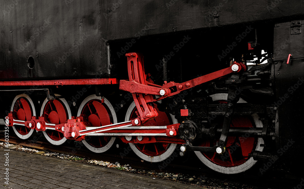 Red metal wheels of a vintage steam locomotive.
