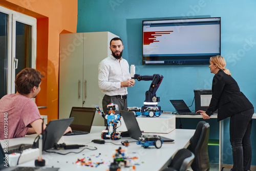 A group of colleagues working together in a robotics laboratory, focusing on the intricate fields of robotics and 3D printing. Showcase their dedication to innovation, as they engage in research