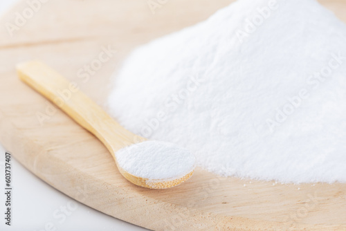 Photos Grape sugar or glucose in a spoon on a wooden board.