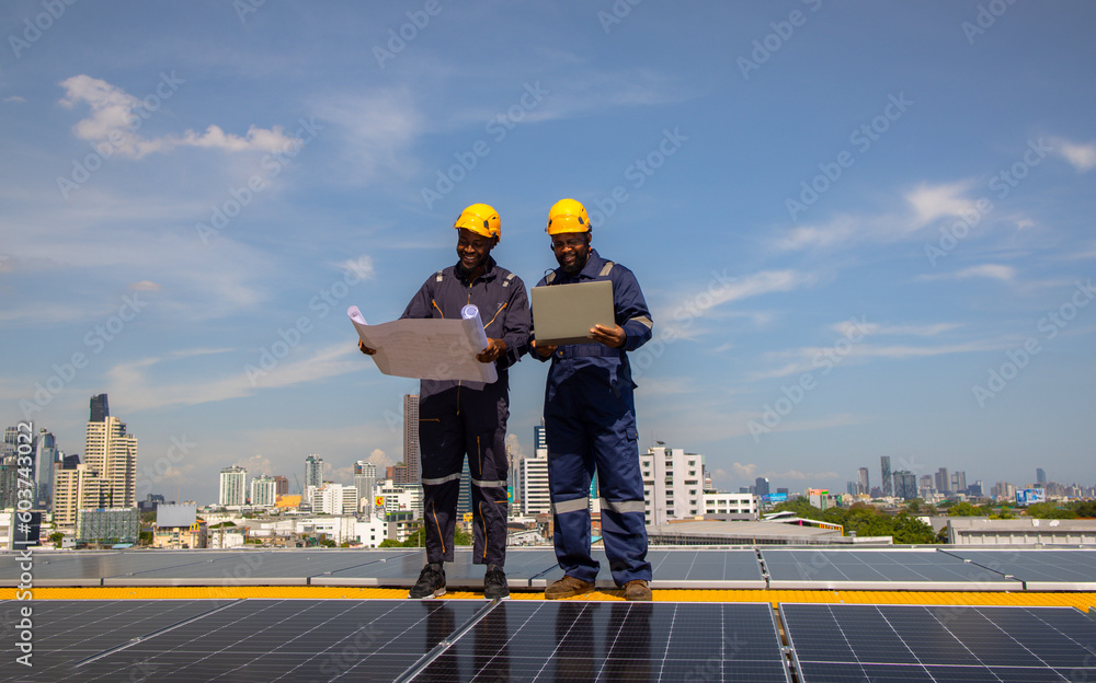 Solar engineer and technician hold blue print drawing discussing on Solar rooftop , technology ecology energy sunlight alternative power factory concept. Solar engineer and technician hold blue print drawing discussing on Solar rooftop , technology ecology energy sunlight alternative power factory concept.