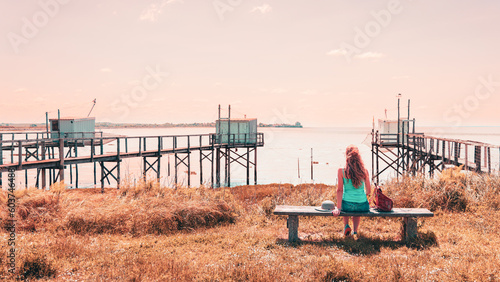 Traveler woman admiring panoramic view of traditional carrelet ( traditional fishing hut)- Charente Maritime- Tour tourism in France,  Gironde estuary