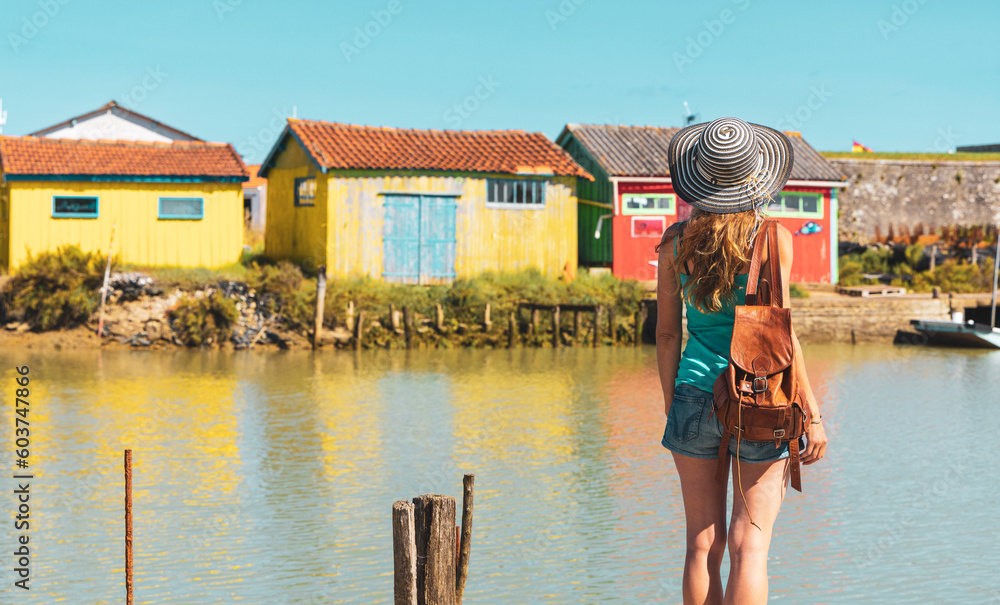 Woman travel in island Oleron- Charente Maritime,  canal with traditional fishing colored house - Tour tourism in France, Nouvelle aquitaine - obrazy, fototapety, plakaty 