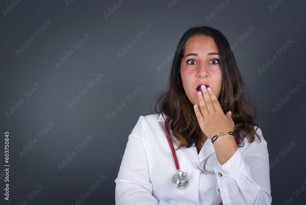 Oh! I think I said it! Close up portrait of lady in white, street style t-shirt cover open mouth by hand palm, look at camera with big eyes isolated on bright mint background. Oh! I think I said it! Close up portrait of lady in white, street style t-shirt cover open mouth by hand palm, look at camera with big eyes isolated on bright mint background.