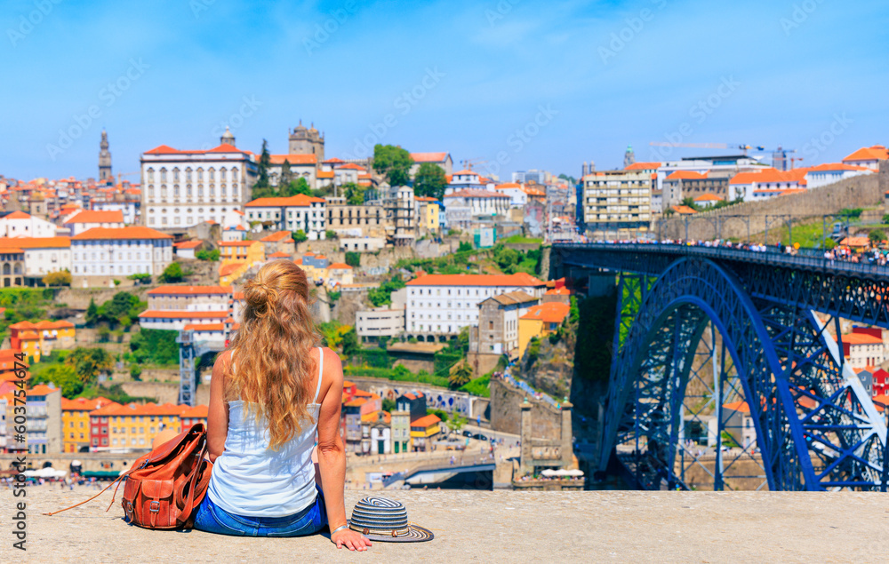 Woman tourist enjoying landscape on the old town with river and famous bridge in Porto city- Portugal - obrazy, fototapety, plakaty 