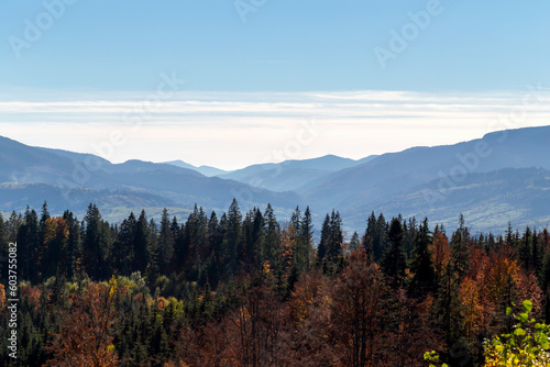 Autumn mountains under blue sky, through which sun's rays break through. The beauty of the Carpathians. Tourism and travel