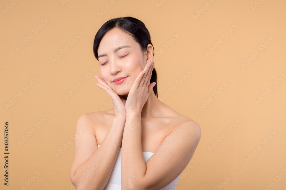 Beautiful girl asian model touching fresh glowing hydrated facial skin on beige background closeup. Beauty face young woman with natural makeup and healthy skin portrait. Skin care concept Beautiful girl asian model touching fresh glowing hydrated facial skin on beige background closeup. Beauty face young woman with natural makeup and healthy skin portrait. Skin care concept