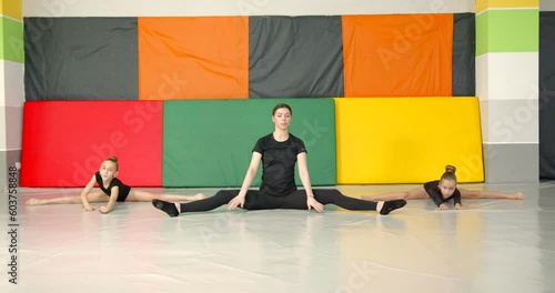 Kids with coach stretching before gymnastics practice