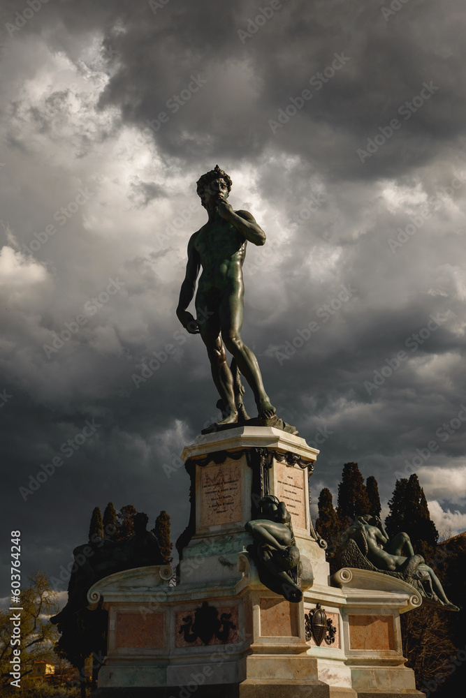 David statue on dramatic clouds background.