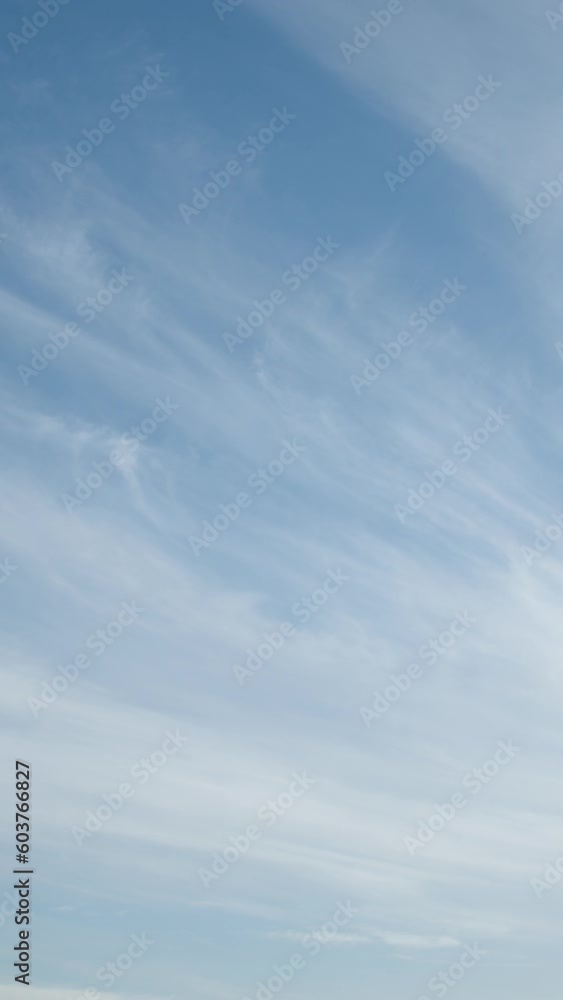 The gently moving cirrus clouds that meander across the serene blue sky provide a simple and natural visual experience. Video timelapse. Vertical video. The gently moving cirrus clouds that meander across the serene blue sky provide a simple and natural visual experience. Video timelapse. Vertical video.