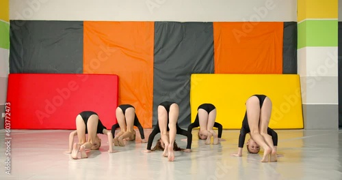 Little girls practice at gymnastics class in a studio