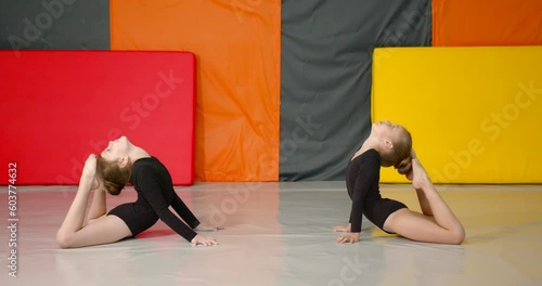 Little girls practice at gymnastics class in a studio
