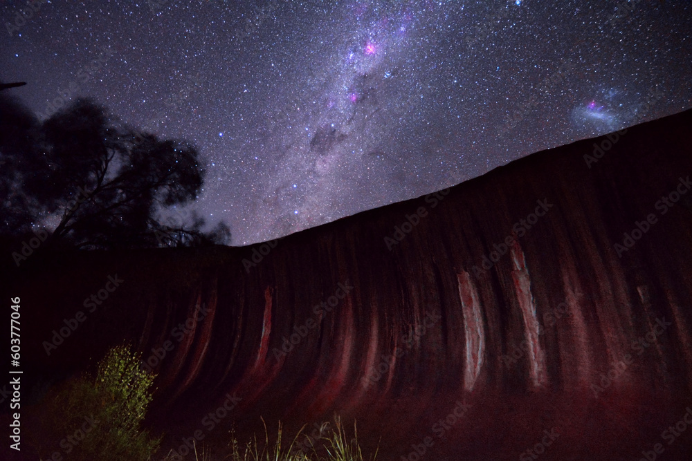 Droga Mleczna i Wielki Obłok Magellana na nocnym niebie w Australii Zachodniej - Nocne niebo nad Waves Rock. - obrazy, fototapety, plakaty 