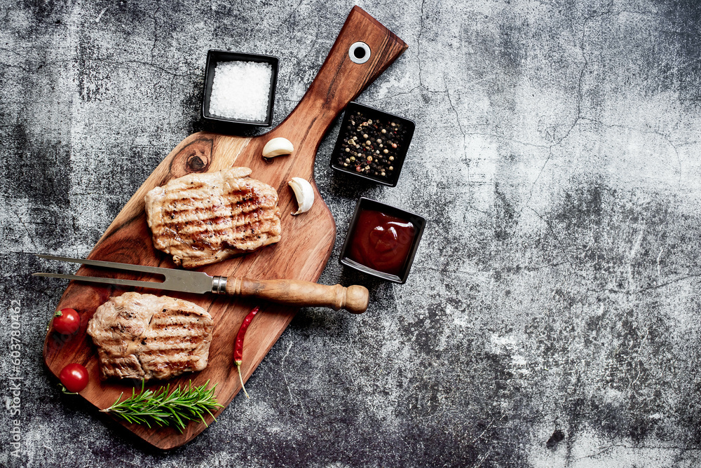 Fototapeta premium grilled veal steaks on stone background with copy space for your text