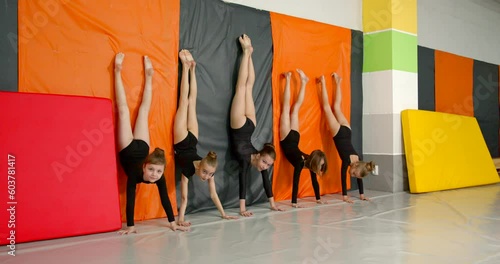Little girls practice at gymnastics class in a studio
