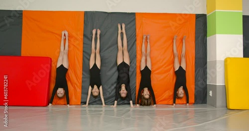 Little girls practice at gymnastics class in a studio