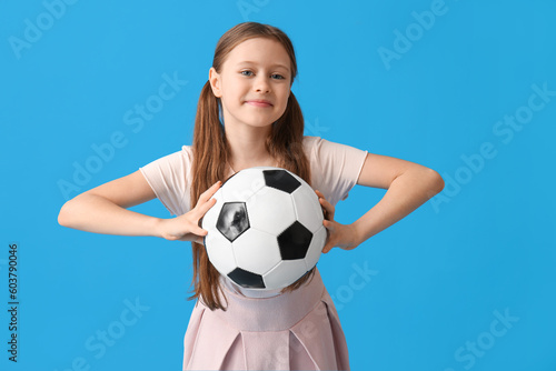 Little girl with soccer ball on blue background © Pixel-Shot