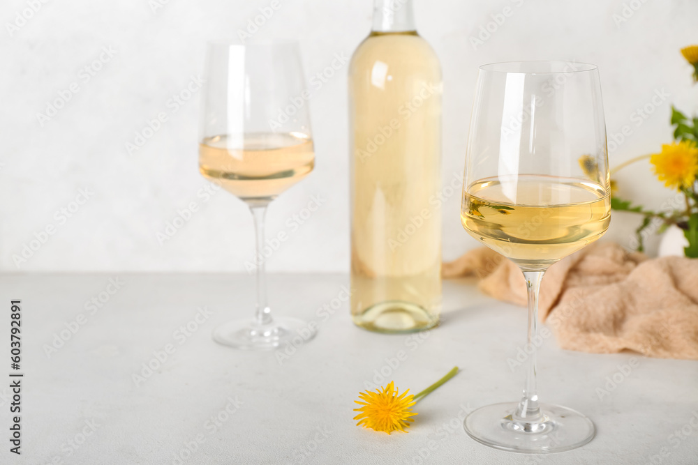 Bottle and glasses of dandelion wine on white table Bottle and glasses of dandelion wine on white table