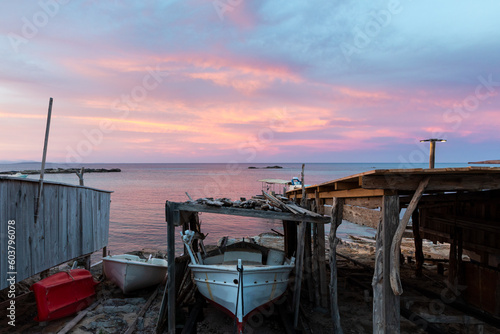 Formentera, Es Pujols beach. Fishing boats on "escars" (traditional wooden jetties) at sunset. Islas Baleares, España.