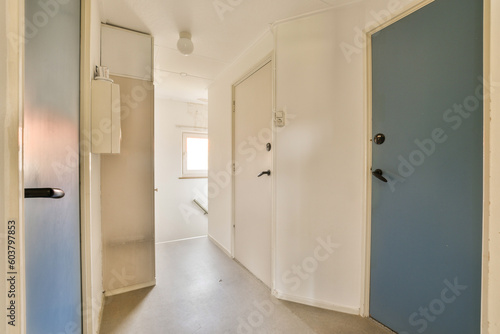 an empty room with blue walls and white trim on the door  there is a light coming in from the window