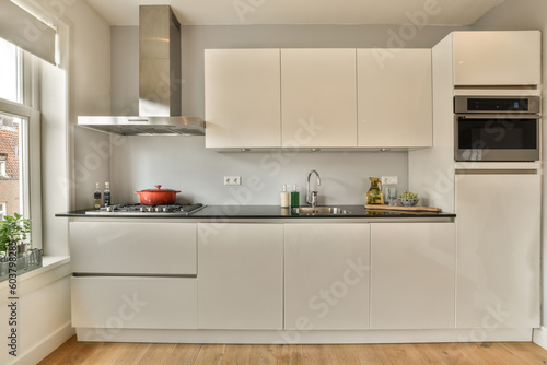 Fototapeta Naklejka Na Ścianę i Meble -  a kitchen with white cabinets and black counter tops on the island in front of the sink is an oven, microwave and dishwasher