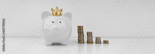 White piggi bank and stacks of coins on white background photo