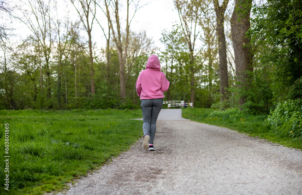 woman running outside,crossing bridge,exercising,tie the sneakers laces.young girl,female with weight problem loss,sport fitness diet,slim fit concept.spring green nature,resting woman.pink hoodie. woman running outside,crossing bridge,exercising,tie the sneakers laces.young girl,female with weight problem loss,sport fitness diet,slim fit concept.spring green nature,resting woman.pink hoodie.