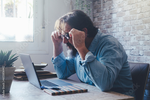 Tablou pe pânză One man adjust glasses to read on computer monitor in smart working home office business activity