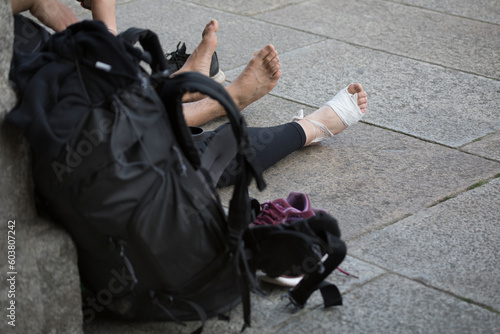 Pilgrims on the Camino de Santiago arrive at the Plaza del Obradoiro because they have finished their pilgrimage. the feet of two barefoot and injured pilgrims at the end of the Camino de Santiago