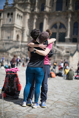 Pilgrims on the Camino de Santiago arrive at the Plaza del Obradoiro because they have finished their pilgrimage. Two pilgrims embrace upon their arrival at the Cathedral of Santiago de Compostela © casavella