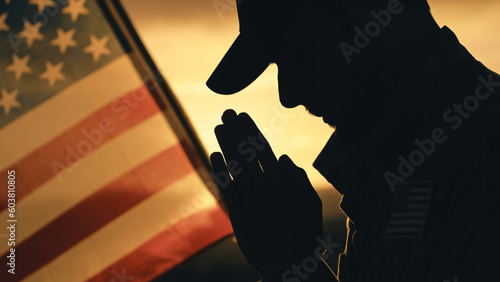 Quadro su tela Silhouette of American soldier praying for memorial day against the flag outdoor