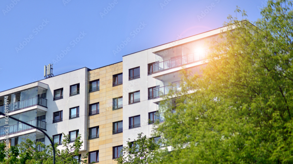 Fototapeta premium Eco architecture. Green tree and new apartment building. The harmony of nature and modernity. Modern residential building with new apartments in a green residential area. 