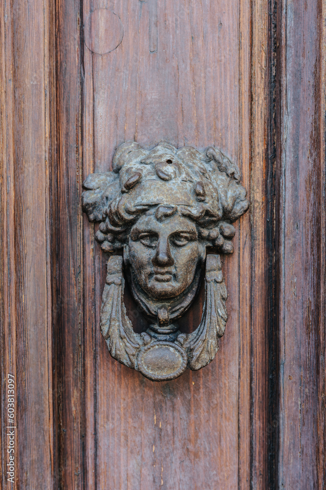 Old face door knocker in Trieste, Italy 