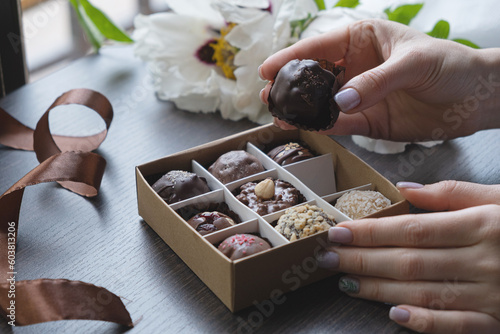 Fotografie Chocolate craft candy in female hand and gift candy box