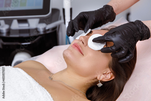 Facial rejuvenation  Dermatology Services  Beauty Skin Care  Cotton pads on the eyes  preparation for a cosmetic procedure. doctor performs a rejuvenation procedure for a woman. IPL procedure