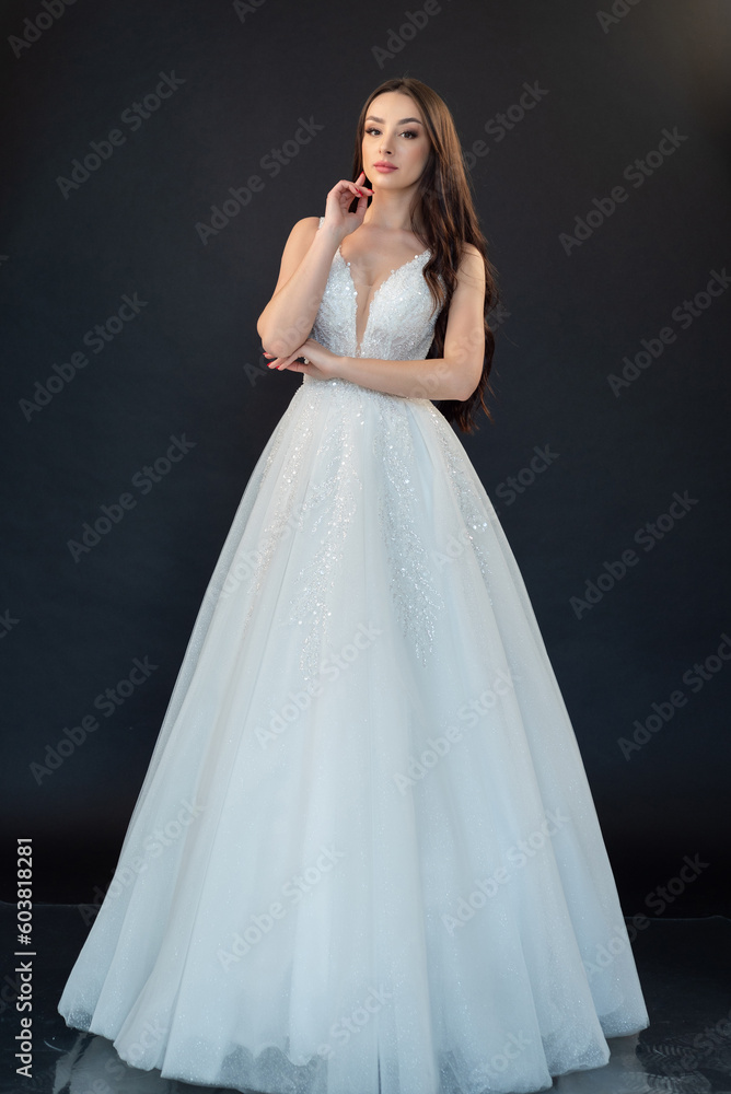 Beautiful bride in wedding dress on black background