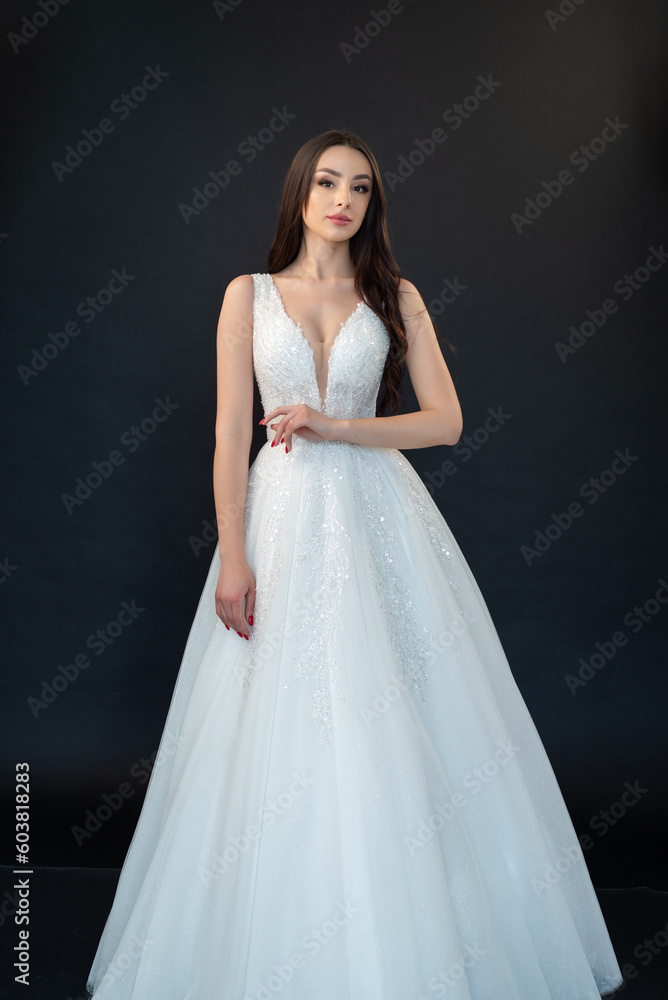 Beautiful bride in wedding dress on black background