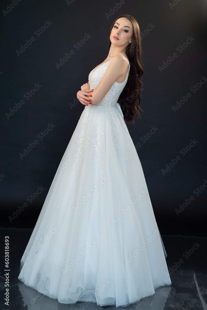 Beautiful bride in wedding dress on black background