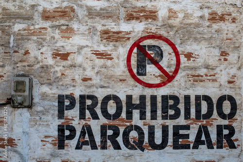 graffiti on a brick wall that says parking is prohibited