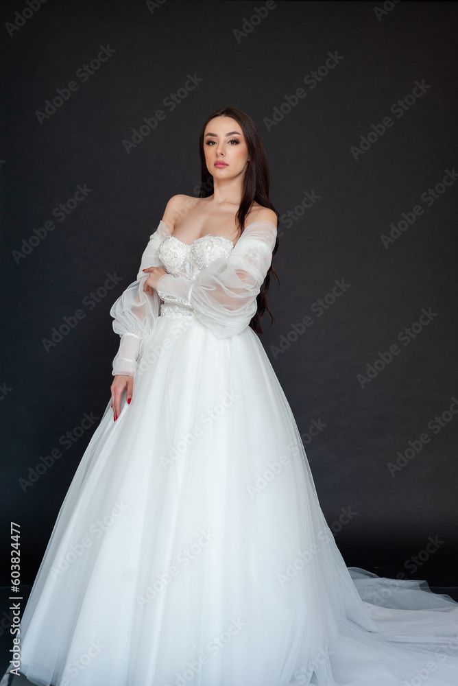  Beautiful fashion bride posing in wedding dress on black background 