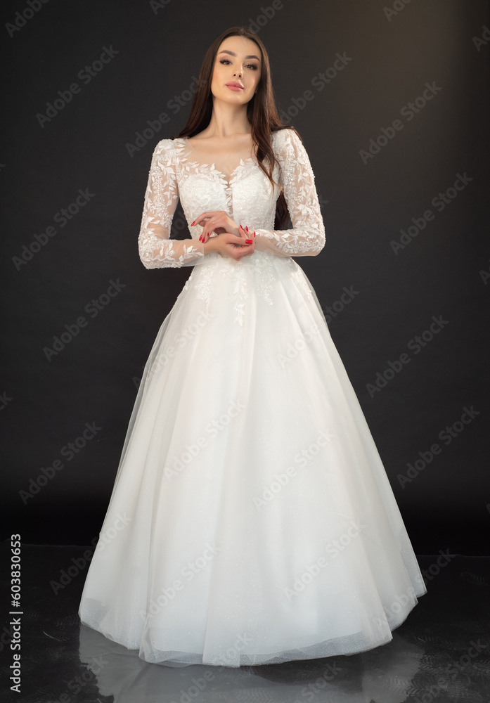 Beautiful fashion bride in wedding dress posing ob black background