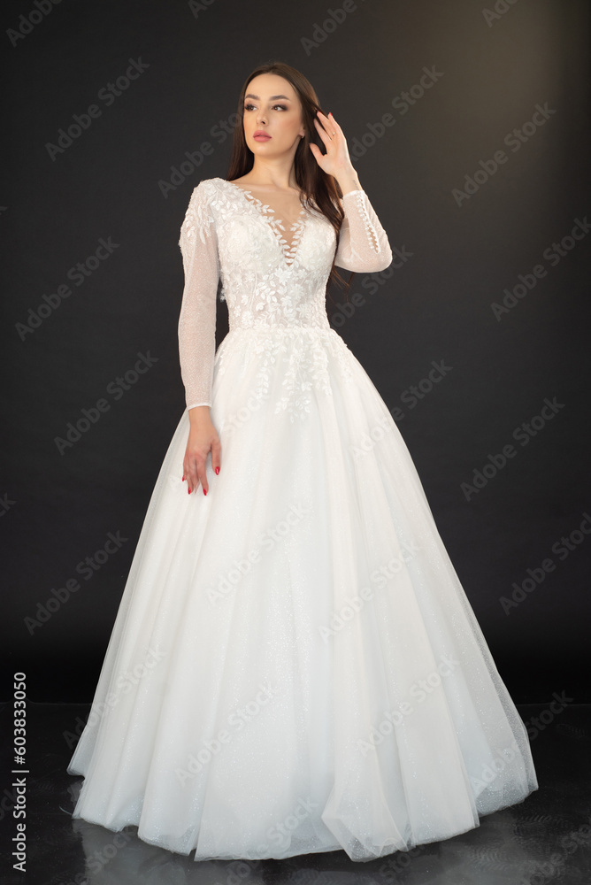 Beautiful fashion bride posing in wedding dress on black background Beautiful fashion bride posing in wedding dress on black background